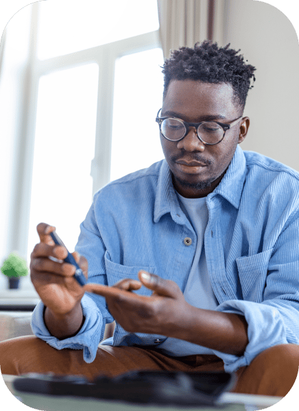 A man with diabetes checks his blood sugar level at home using a glucose meter